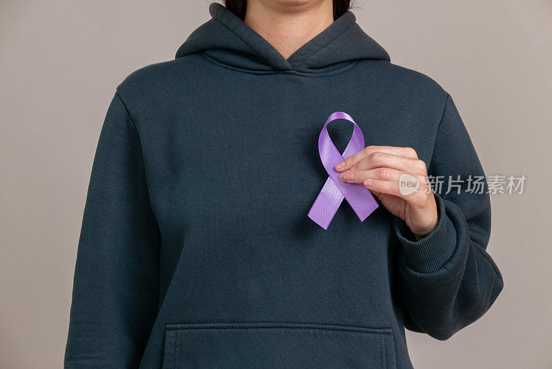 妇女手持紫色丝带在她的手中ADD,ADHD，阿尔茨海默病，Arnold Chiari畸形，儿童偏瘫中风，癫痫，慢性急性疼痛，克罗恩